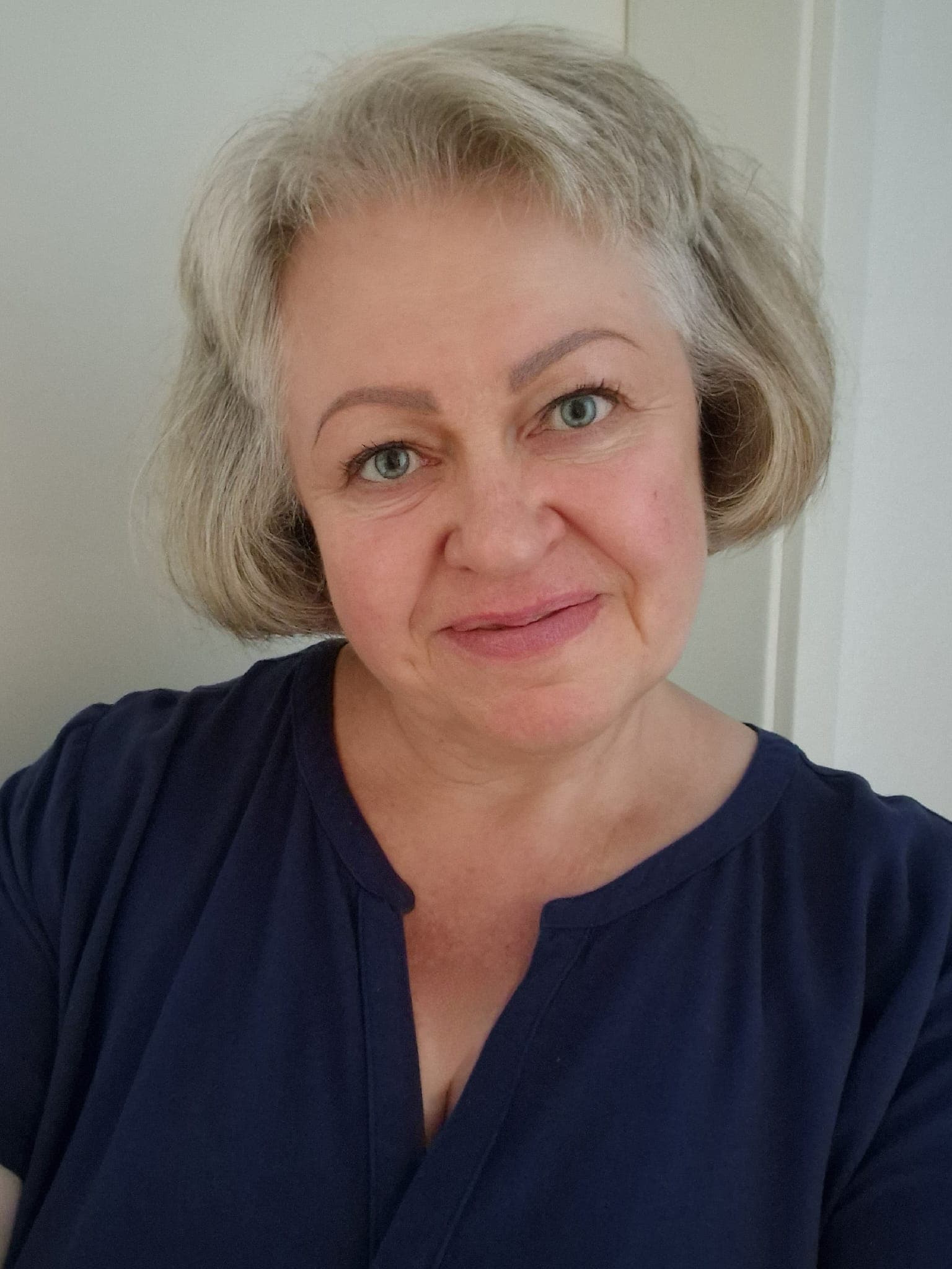 Porträt der Inhaberin - Eine freundliche Frau mit kurzen blonden Haaren in einer dunkelblauen Bluse